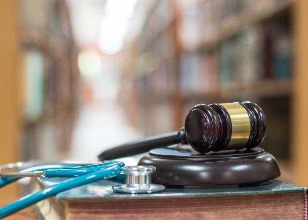 forensic medicine investigation or malpractice justice concept with judge gavel and medical stethoscope on law textbook in library archive study room - intellectual property law patent book imagens e fotografias de stock