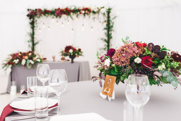 istock Wedding table, decorated with red flowers bouquets, candles, grey tablecloth, and white plates 1026273300