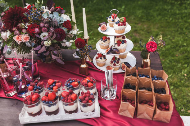 istock Fresh tasty cupcakes with berries on wedding reception table, decorated in red colour with flowers 1026273458