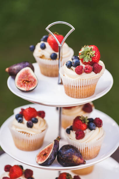 istock Fresh tasty cupcakes with berries on wedding reception table, decorated in red colour with flowers 1026273468