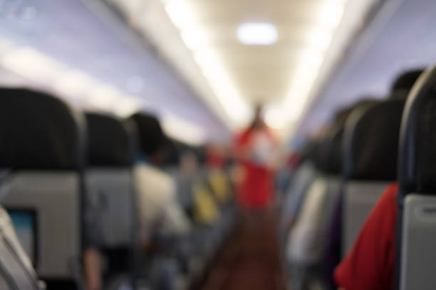 istock passenger sit on seat in airplane.  aisle in aeroplane interior. blur background 1026273634