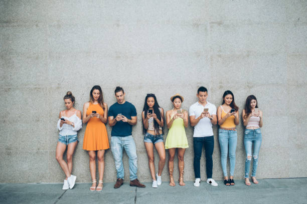 istock Friends leaning back on a wall and social networking 1026273980