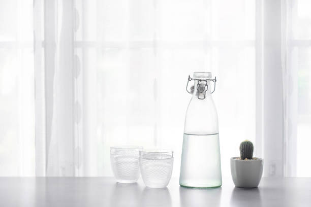 istock Glass of water with a bottle on table 1026274534