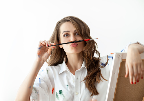 Retrato de mujer joven que se enfrenta y representa el bigote con ayuda del pincel photo