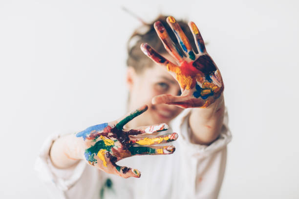 Happy woman hiding the face with her painted hands