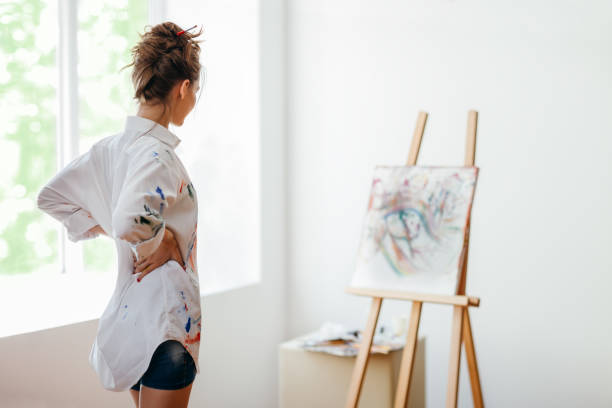istock artist analyze her painting in art studio 1026279710