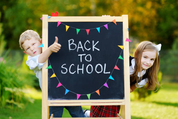 Two adorable little schoolkids feeling excited about going back to school