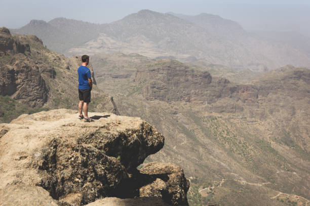 istock Tourist on mountain edge facing great landscape views 1026294000