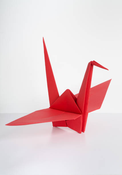 Red Origami Crane Red origami crane ( tsuru ) photographed on white base with white wall as background. origami cranes stock pictures, royalty-free photos & images