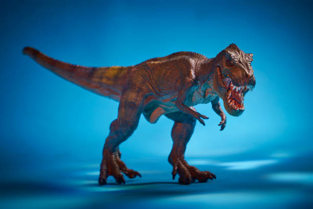 Vibrant toy dinosaur on expansive salt flat under vivid blue sky. Colorful children's toy in unique outdoor setting. Creative composition with bright colors and open space.