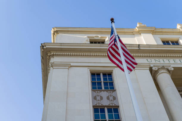 istock US Flag on Flagpole Outside of US Postal Office Building Low Angle View 1026360248