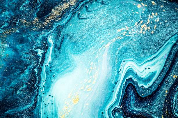 Abstract ocean- ART. Natural Luxury. Style incorporates the swirls of marble or the ripples of agate. Very beautiful blue paint with the addition of gold powder. Magic wallpaper, texture. Paper marbling is a method of aqueous surface design, which can produce patterns similar to smooth marble or other kinds of stone. Gouache painting- can be used as a trendy background. 2019 photos stock pictures, royalty-free photos & images