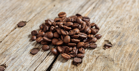 Coffee beans heap on a wooden surface