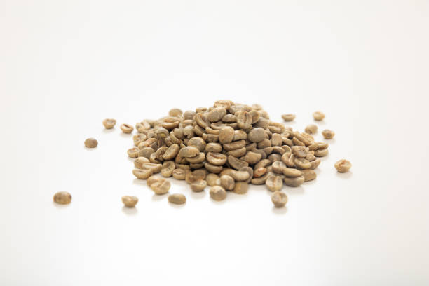Scattered light brown mature coffee beans on a wooden table in a closeup view, with macro photograph.