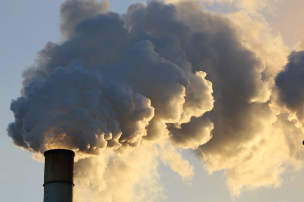 Mining industry depicting smoke stacks and emissions as a result of mining for minerals and other metals. Smoke or pollution released into the sky . Sugar cane also emits vapor from smokestacks. Global warming and non renewable energy resources. humo de la industria de explotación minera pilas mostrando las plumas de las emisiones de humo o vapor siendo lanzadas hacia el cielo. minería y la extracción de minerales valiosos, materiales geológicos de la tierra, generalmente de un cuerpo mineral,