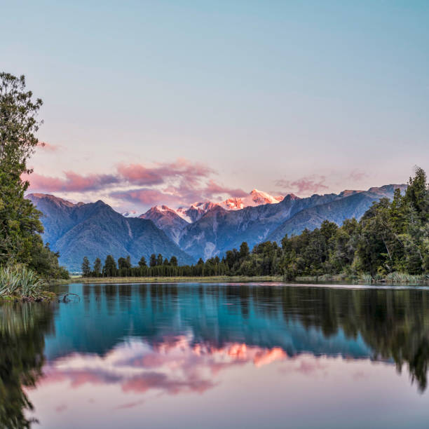 Mount Cook Lake Matheson Reflection New Zealand Lake Matheson at sunset with snow covered Mount Cook, New Zealand's highest mountain. fox glacier photos stock pictures, royalty-free photos & images