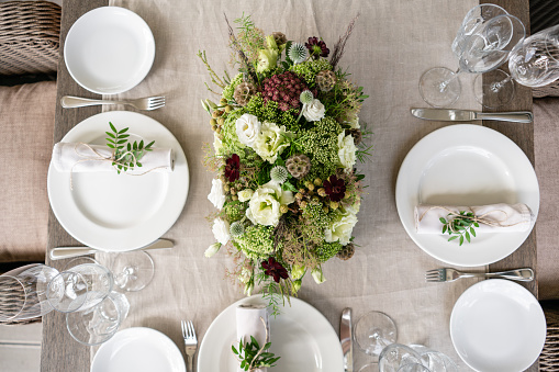 Wedding Banquet or gala dinner. The chairs and table for guests, served with cutlery and crockery. Covered with a linen tablecloth runner. party on terrace.