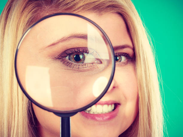 istock Woman looking through magnifying glass 1026424484