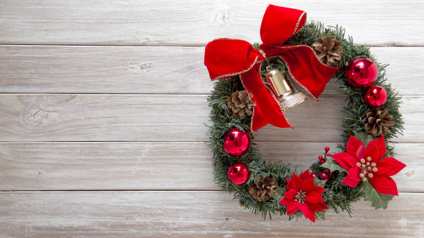 istock Christmas Wreath with red bow on rustic old white wooden 1026434564