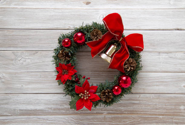 istock Christmas Wreath with red bow on rustic old white wooden 1026434638