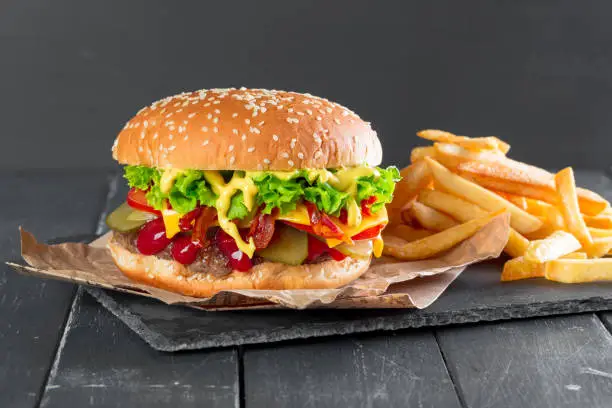 Photo of Hamburger with fries on a slate plate