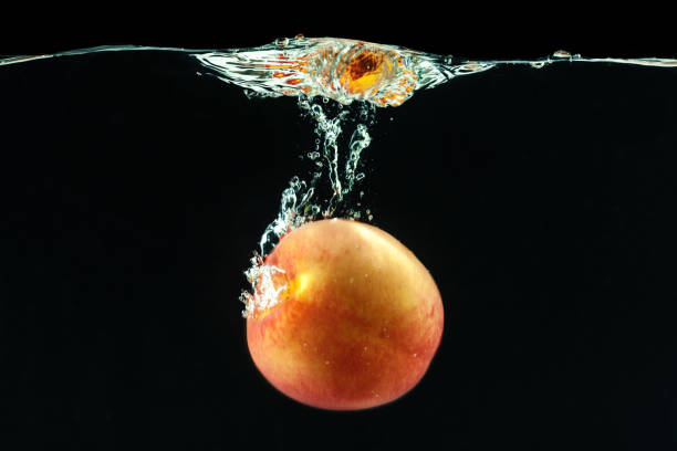 Peach dropped into water with bubbles