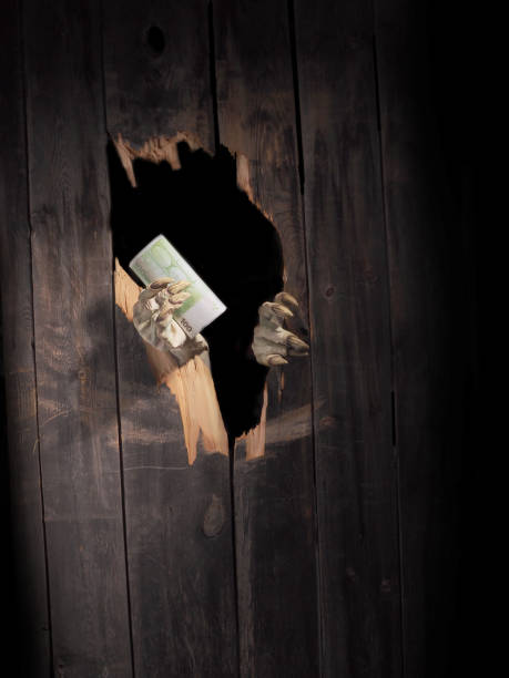 istock Zombie hand through hole cracked in rustic wood.Halloween theme 1026444698