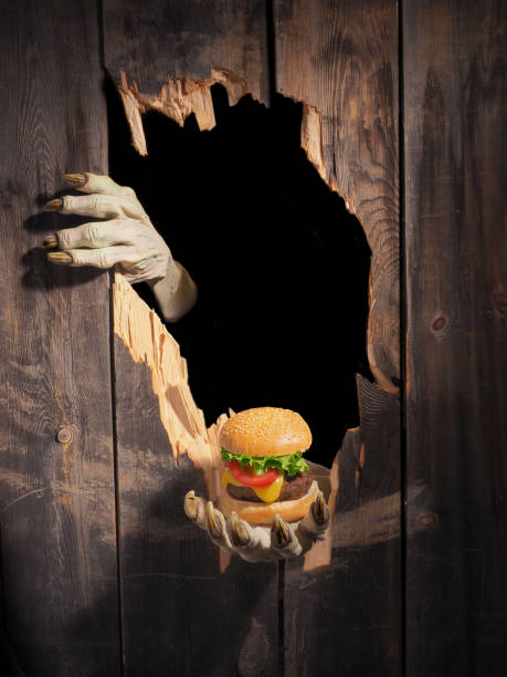 Zombie hand through hole cracked in rustic wood.Halloween theme