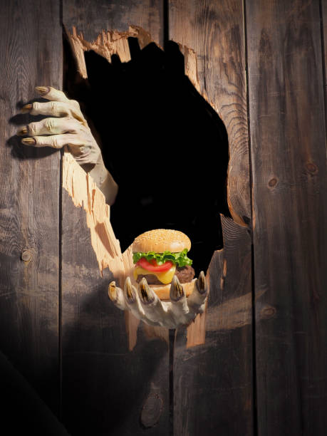 istock Zombie hand through hole cracked in rustic wood.Halloween theme 1026447828