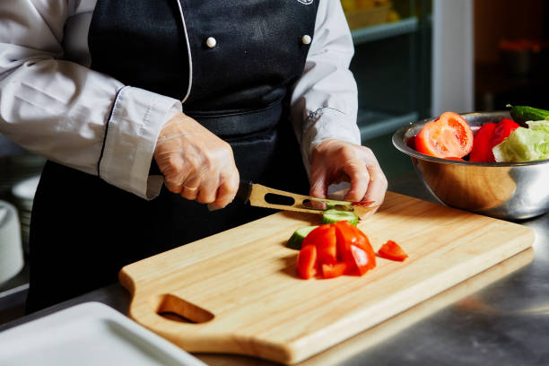 istock The chef in the cafe cuts tomatoes on a wooden kitchen Board 1026448880