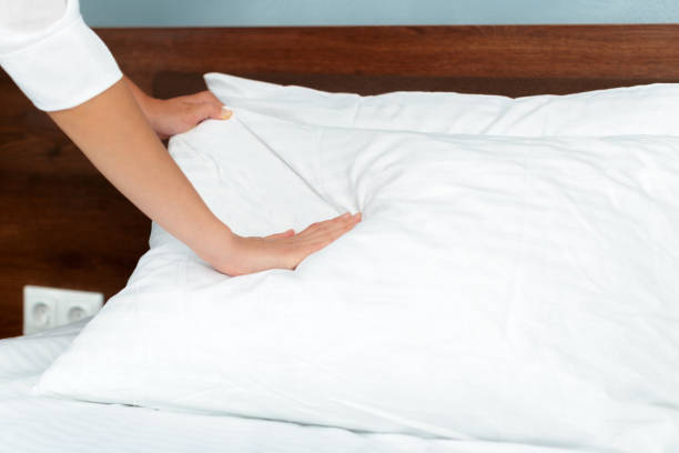 istock Young maid making bed in hotel room 1026451366