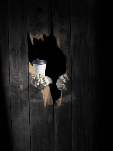 istock Zombie hand through hole cracked in rustic wood.Halloween theme 1026452064