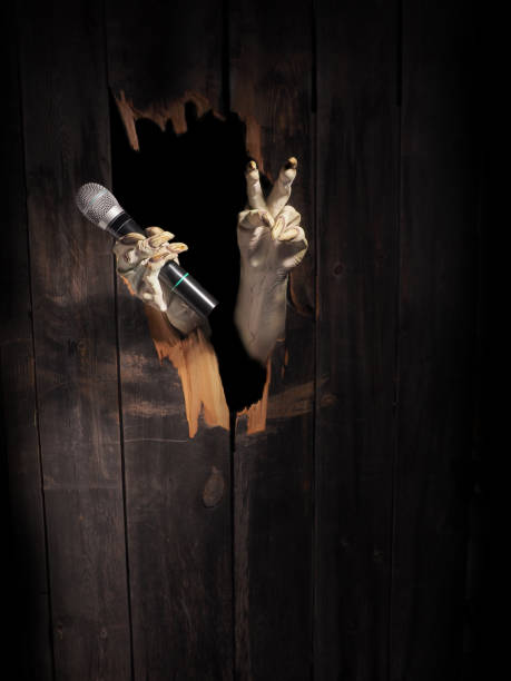 istock Zombie hand through hole cracked in rustic wood.Halloween theme 1026456580