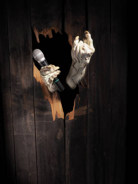 istock Zombie hand through hole cracked in rustic wood.Halloween theme 1026456640