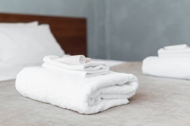 istock White towel on bed in guest room for hotel customer 1026458092