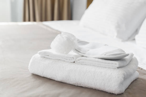 istock White towel on bed in guest room for hotel customer 1026458094
