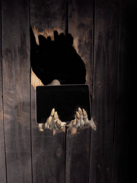 istock Zombie hand through hole cracked in rustic wood.Halloween theme 1026458582