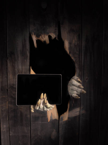 istock Zombie hand through hole cracked in rustic wood.Halloween theme 1026458616