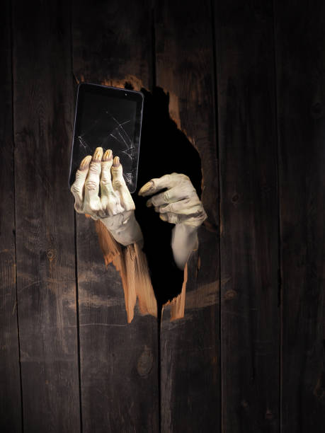 istock Zombie hand through hole cracked in rustic wood.Halloween theme 1026460930