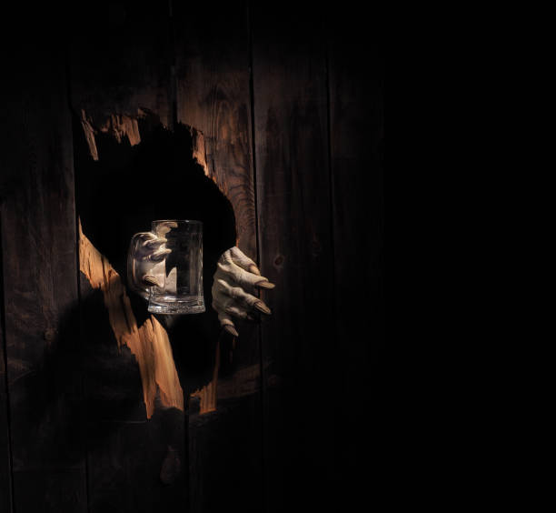 istock Zombie hand through hole cracked in rustic wood.Halloween theme 1026472808