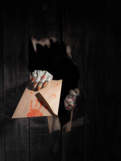 istock Zombie hand through hole cracked in rustic wood.Halloween theme 1026473242