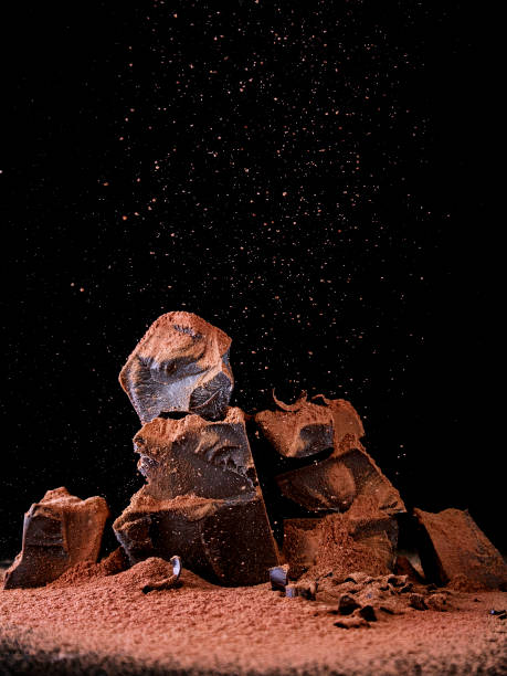 istock Chocolate blocks are sprinkled with cocoa powder on a dark black background. 1026477112