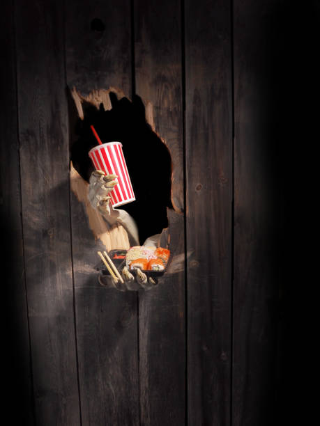 istock Zombie hand through hole cracked in rustic wood.Halloween theme 1026477504