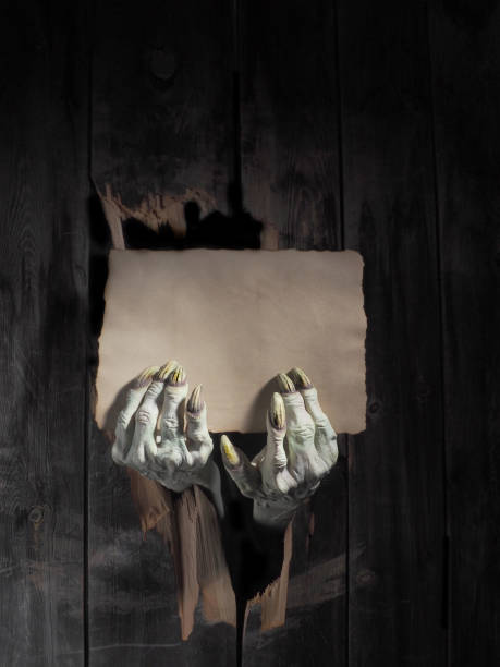 istock Zombie hand through hole cracked in rustic wood.Halloween theme 1026479796