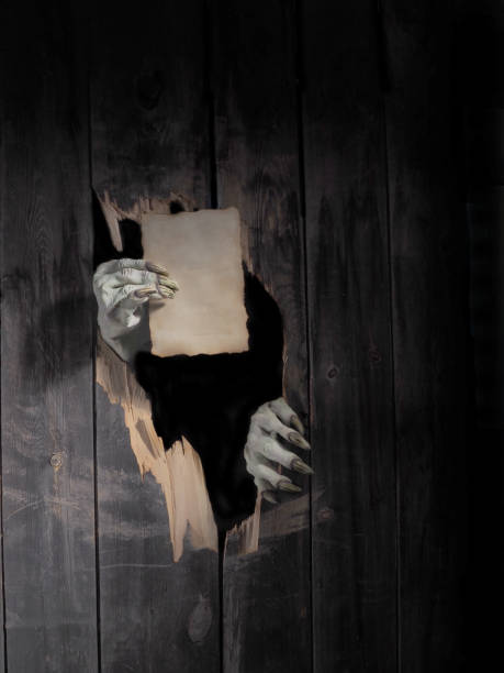 Zombie hand through hole cracked in rustic wood.Halloween theme