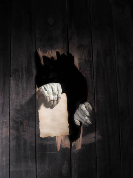 istock Zombie hand through hole cracked in rustic wood.Halloween theme 1026479854