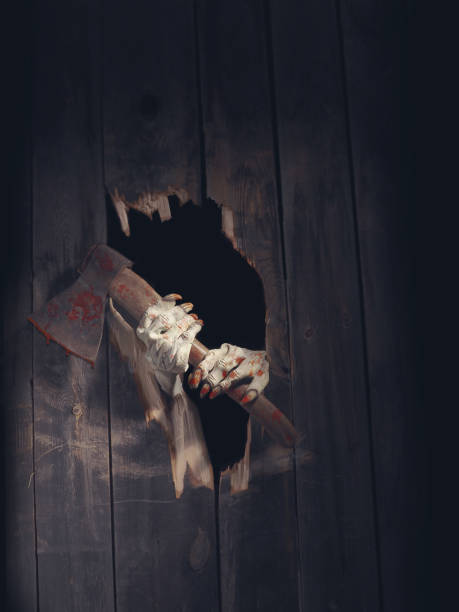 istock Zombie hand through hole cracked in rustic wood.Halloween theme 1026480020