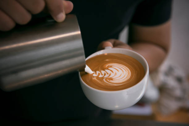 istock Barista making latte or Cappuccino with frothy foam, coffee cup in cafe. 1026480974
