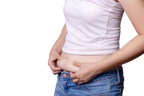 アジアの女性体脂肪腹側面図との手絞るクリッピング パス、白い背景の上に余分な脂肪を分離、します。 - fat burning ストックフォトと画像