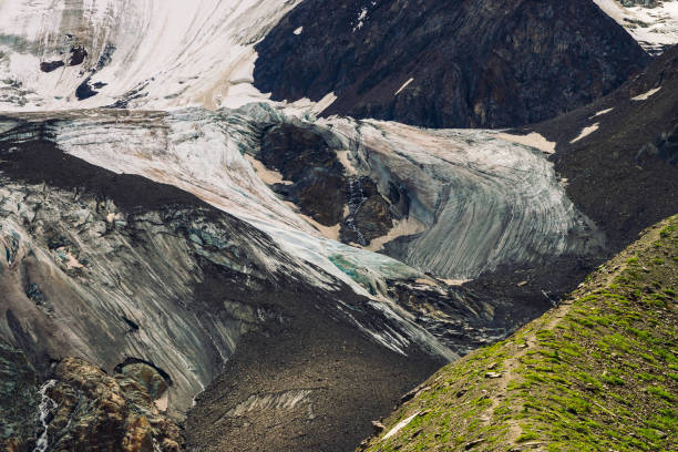 détaillée de texture naturelle du mont géant recouvert de neige et de glace. petits ruisseaux écoulement vers le bas de la montagne. rock avec image de gros yeux pleurant. sentier dans les highlands. oeuvre de fantaisie de la nature majestueuse. - waterfall rock mountain bright photos et images de collection